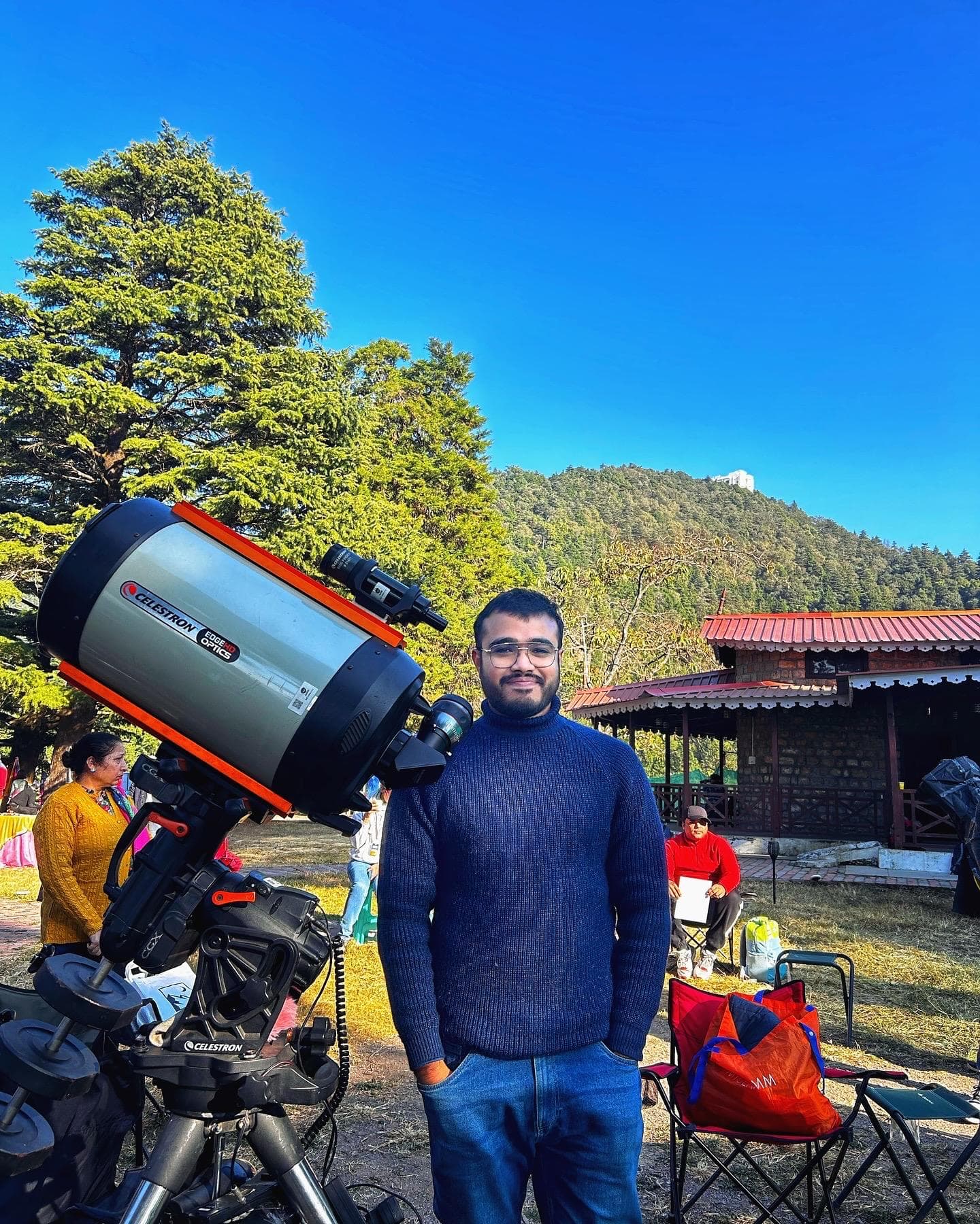 Kshitij beside a Celestron telescope at an outdoor observing session